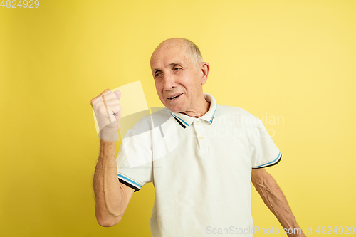 Image of Caucasian senior man\'s portrait isolated on yellow studio background