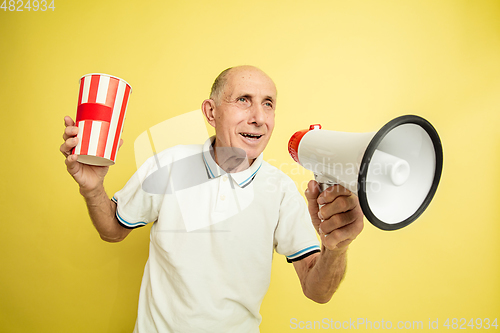 Image of Caucasian senior man\'s portrait isolated on yellow studio background