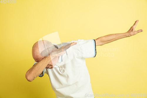 Image of Caucasian senior man\'s portrait isolated on yellow studio background