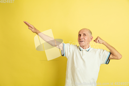 Image of Caucasian senior man\'s portrait isolated on yellow studio background