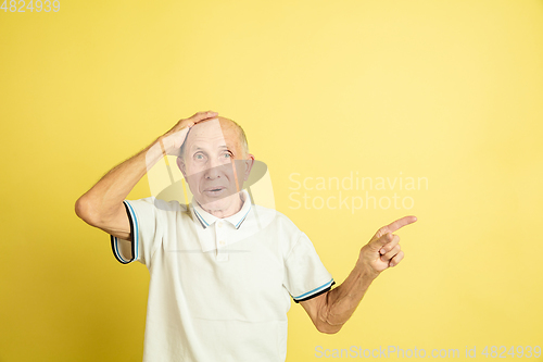 Image of Caucasian senior man\'s portrait isolated on yellow studio background