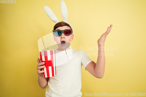 Image of Easter bunny boy with bright emotions on yellow studio background