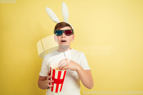 Image of Easter bunny boy with bright emotions on yellow studio background