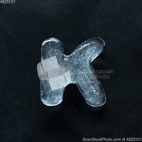 Image of Alphabet\'s letters made out of ice isolated on dark studio background