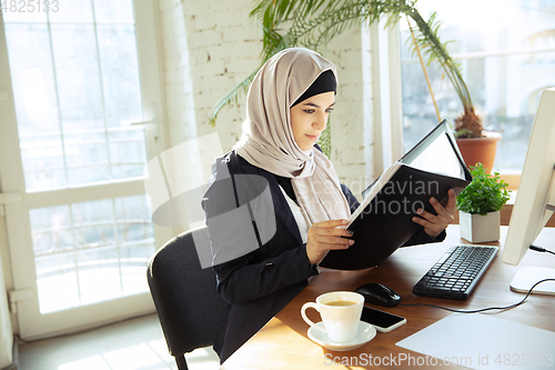 Image of Portrait of a beautiful arabian businesswoman wearing hijab while working