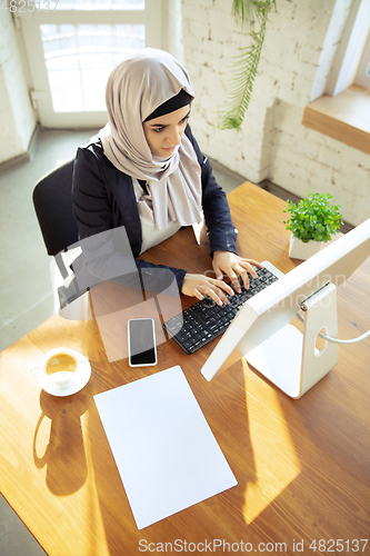 Image of Portrait of a beautiful arabian businesswoman wearing hijab while working