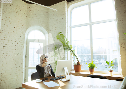 Image of Portrait of a beautiful arabian businesswoman wearing hijab while working