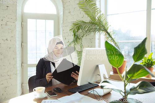 Image of Portrait of a beautiful arabian businesswoman wearing hijab while working