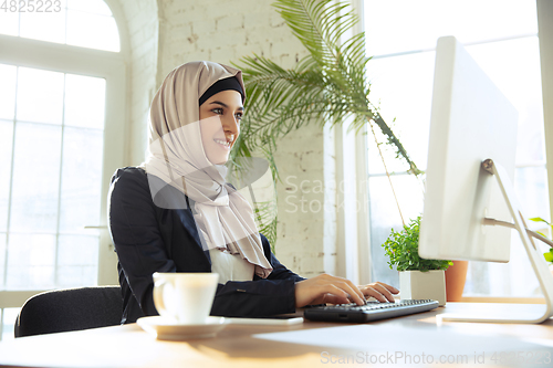 Image of Portrait of a beautiful arabian businesswoman wearing hijab while working