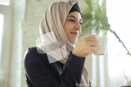 Image of Portrait of a beautiful arabian businesswoman wearing hijab while working