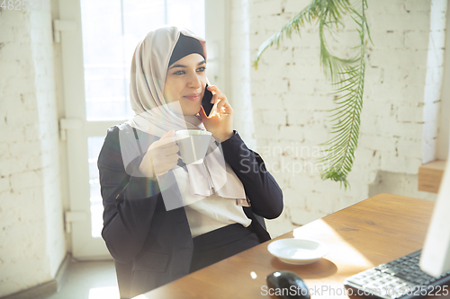 Image of Portrait of a beautiful arabian businesswoman wearing hijab while working