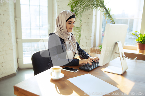 Image of Portrait of a beautiful arabian businesswoman wearing hijab while working