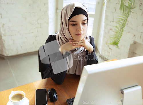 Image of Portrait of a beautiful arabian businesswoman wearing hijab while working