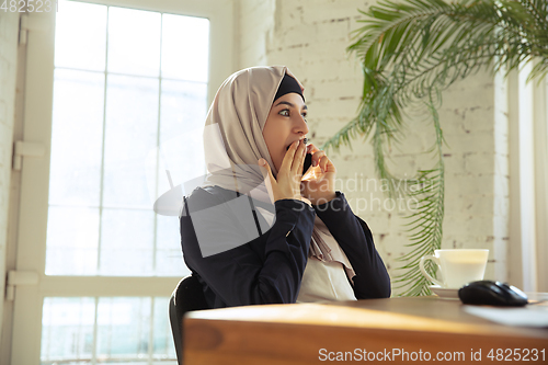 Image of Portrait of a beautiful arabian businesswoman wearing hijab while working