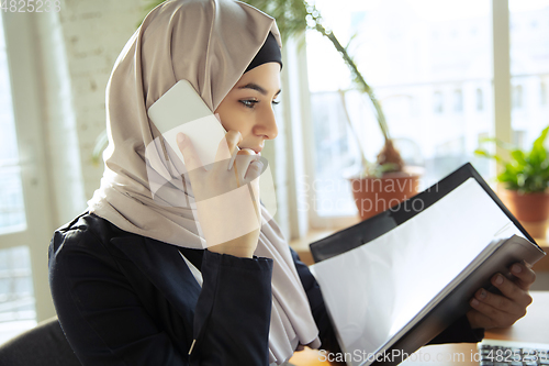 Image of Portrait of a beautiful arabian businesswoman wearing hijab while working