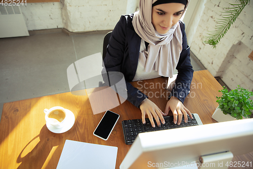 Image of Portrait of a beautiful arabian businesswoman wearing hijab while working