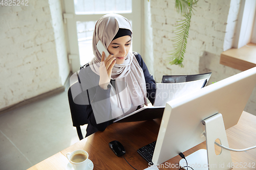 Image of Portrait of a beautiful arabian businesswoman wearing hijab while working