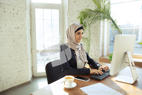 Image of Portrait of a beautiful arabian businesswoman wearing hijab while working