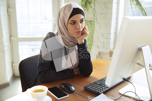 Image of Portrait of a beautiful arabian businesswoman wearing hijab while working