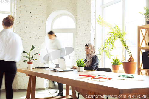 Image of Portrait of a beautiful arabian businesswoman wearing hijab while working
