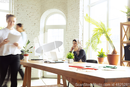 Image of Portrait of a beautiful arabian businesswoman wearing hijab while working