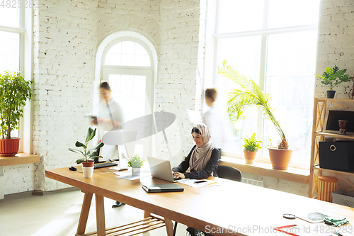 Image of Portrait of a beautiful arabian businesswoman wearing hijab while working