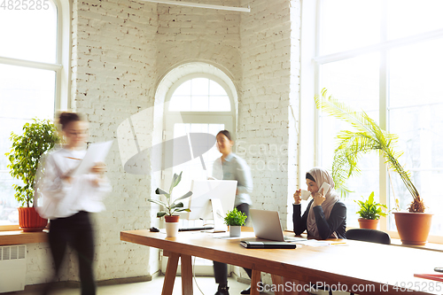 Image of Portrait of a beautiful arabian businesswoman wearing hijab while working