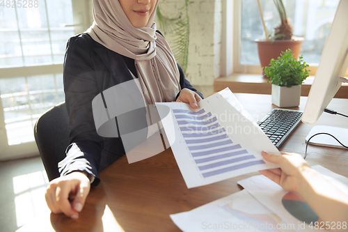 Image of Portrait of a beautiful arabian businesswoman wearing hijab while working