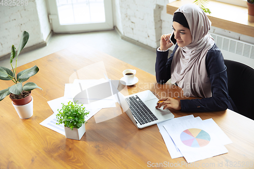 Image of Portrait of a beautiful arabian businesswoman wearing hijab while working