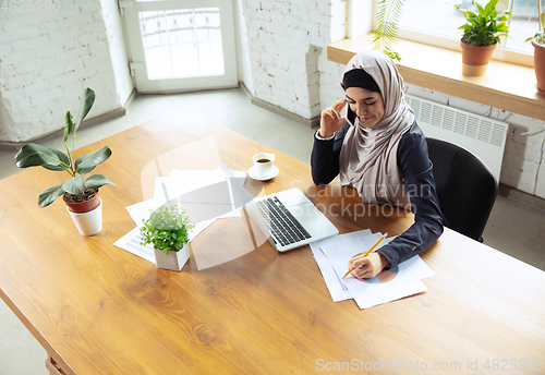 Image of Portrait of a beautiful arabian businesswoman wearing hijab while working