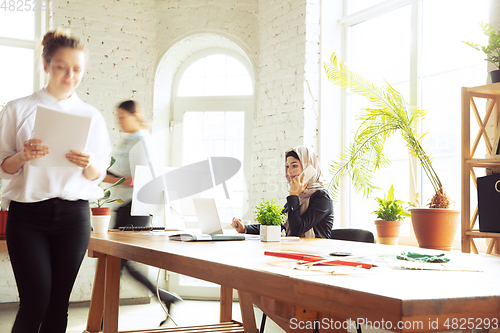 Image of Portrait of a beautiful arabian businesswoman wearing hijab while working