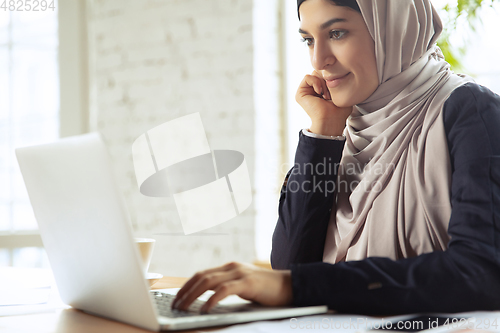 Image of Portrait of a beautiful arabian businesswoman wearing hijab while working