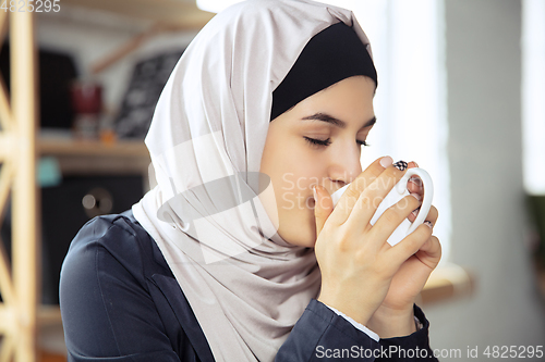 Image of Portrait of a beautiful arabian businesswoman wearing hijab while working
