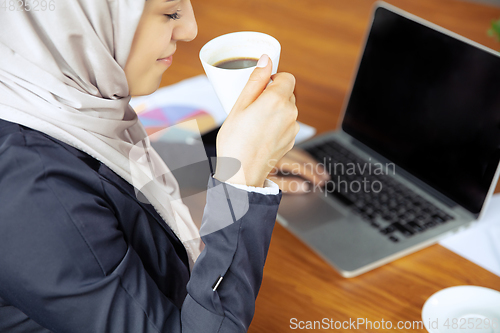 Image of Portrait of a beautiful arabian businesswoman wearing hijab while working