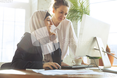 Image of Portrait of a beautiful arabian businesswoman wearing hijab while working