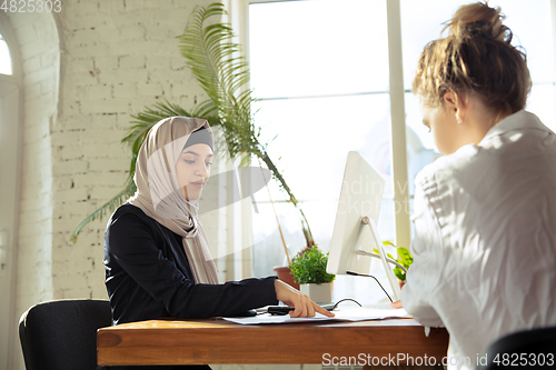 Image of Portrait of a beautiful arabian businesswoman wearing hijab while working