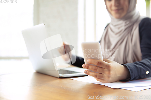 Image of Portrait of a beautiful arabian businesswoman wearing hijab while working