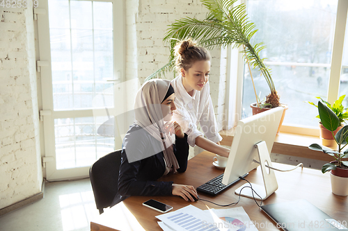 Image of Portrait of a beautiful arabian businesswoman wearing hijab while working