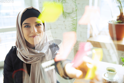 Image of Portrait of a beautiful arabian businesswoman wearing hijab while working