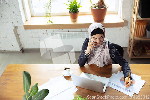 Image of Portrait of a beautiful arabian businesswoman wearing hijab while working