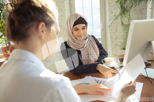 Image of Portrait of a beautiful arabian businesswoman wearing hijab while working