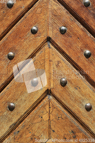 Image of Closeup of old vintage wooden doors with metal rivets