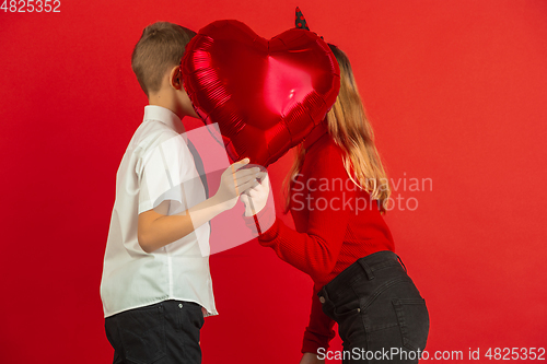 Image of Valentine\'s day celebration, happy caucasian kids isolated on red background