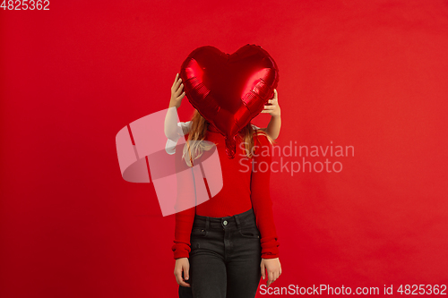 Image of Valentine\'s day celebration, happy caucasian kids isolated on red background