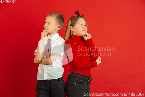 Image of Valentine\'s day celebration, happy caucasian kids isolated on red background