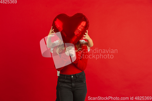 Image of Valentine\'s day celebration, happy caucasian kids isolated on red background