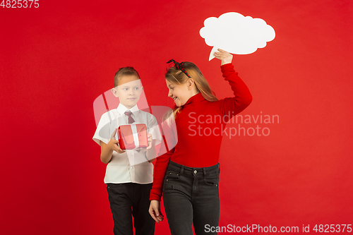 Image of Valentine\'s day celebration, happy caucasian kids isolated on red background