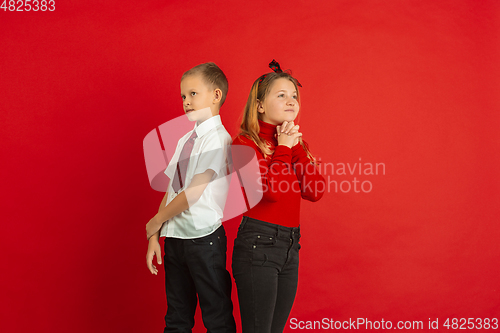 Image of Valentine\'s day celebration, happy caucasian kids isolated on red background