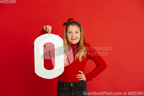 Image of Valentine\'s day celebration, happy caucasian girl holding letter on red background