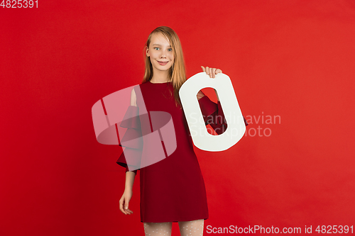 Image of Valentine\'s day celebration, happy caucasian girl holding letter on red background